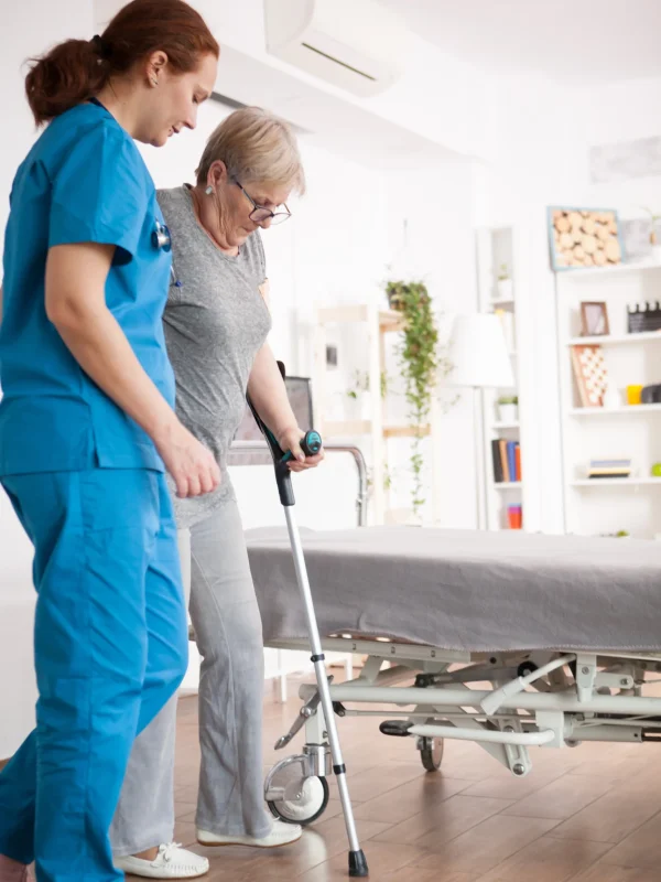 female-nurse-helping-old-woman-with-walking-problem-nursing-home-using-crutches